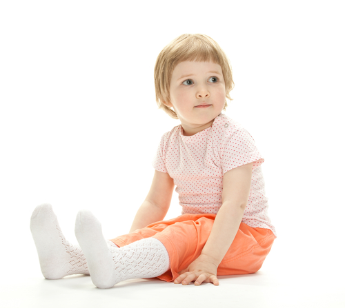 Enfant assis avec les jambes droites