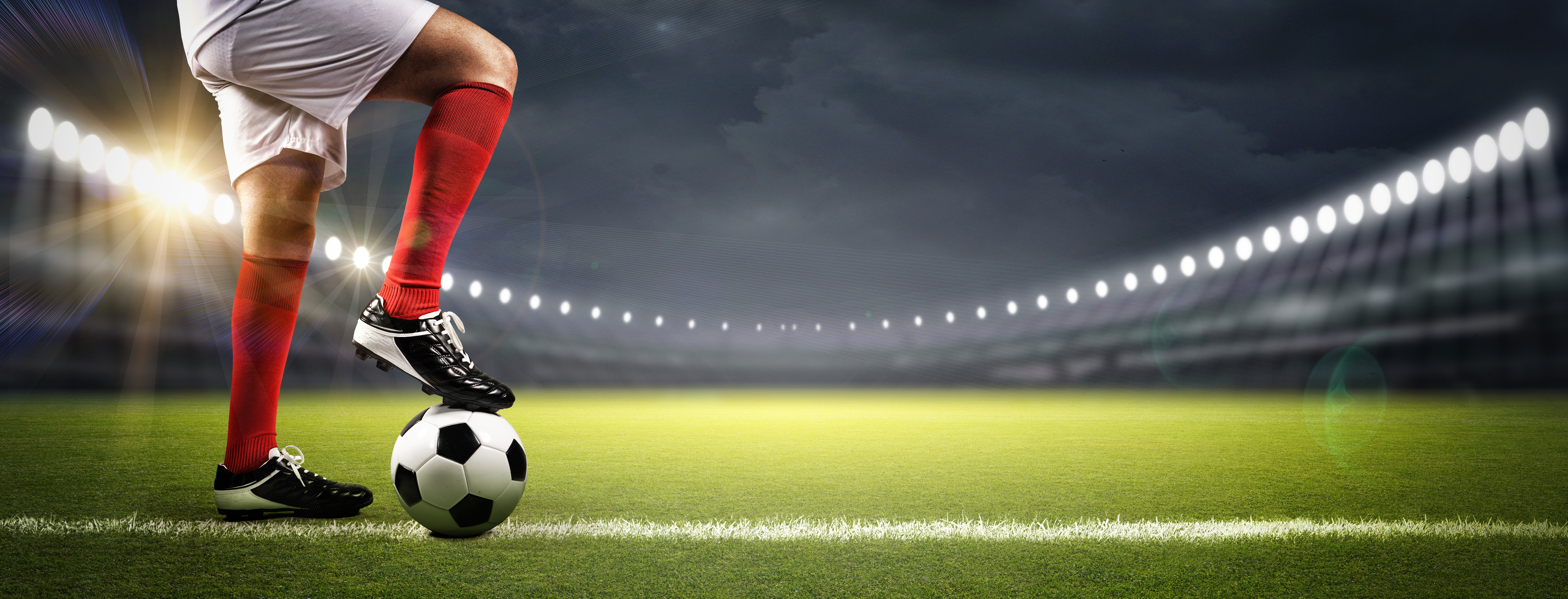 Joueur de soccer sur un terrain qui a le pied sur le ballon avec la jambe fléchi