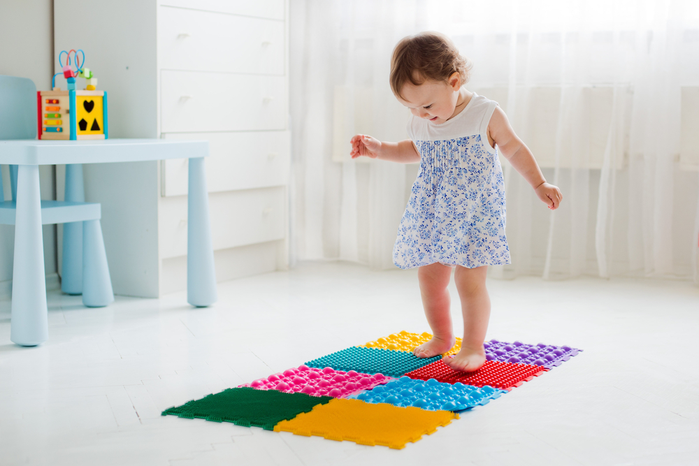 Enfant qui marche sur un tapis de proprioception