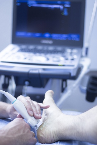 Podiatre qui fait une échographie du pied