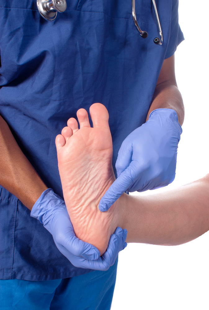 Podiatre avec des gants qui pointe le talon d'un patient sur son pied