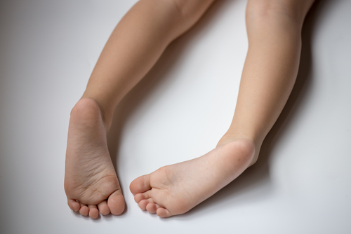 Enfant couché sur le ventre avec les pieds qui pointent un vers l'autre