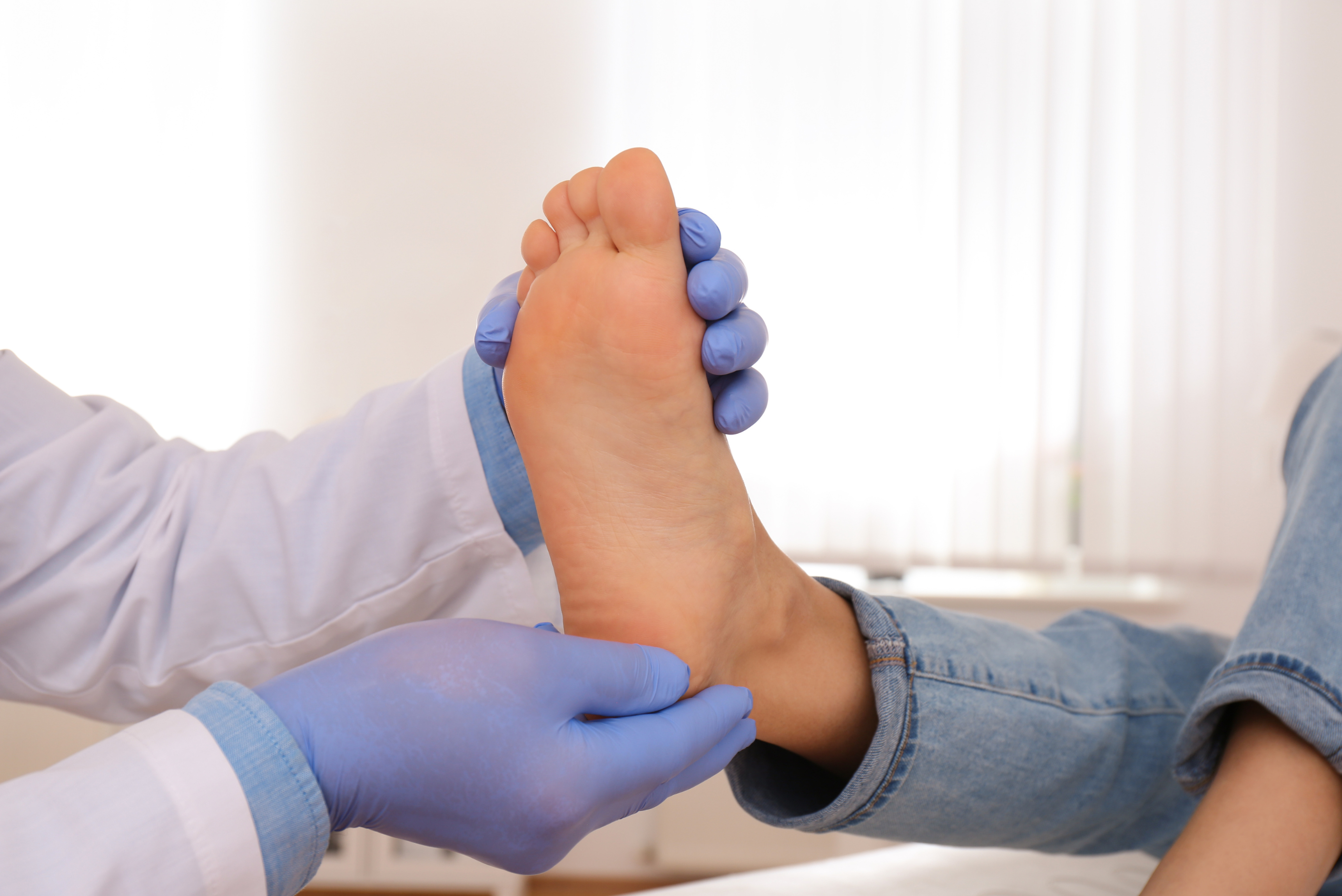 Podiatre qui tient le pied d'un enfant dans ses mains